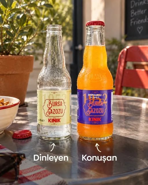 Bir kafe masasında KINIK Bursa Gazozu sade ve portakallı